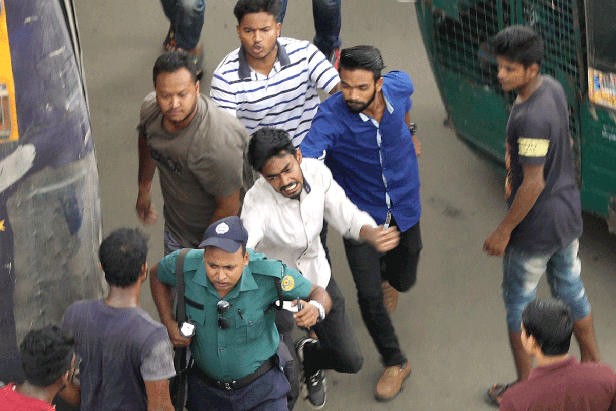 A group of young men assault a police officer at the New Market intersection of Chattogram as he charged a motorcyclist for driving the wrong way. The photo was taken around 1:40pm on Sunday. Photo: Prothom Alo