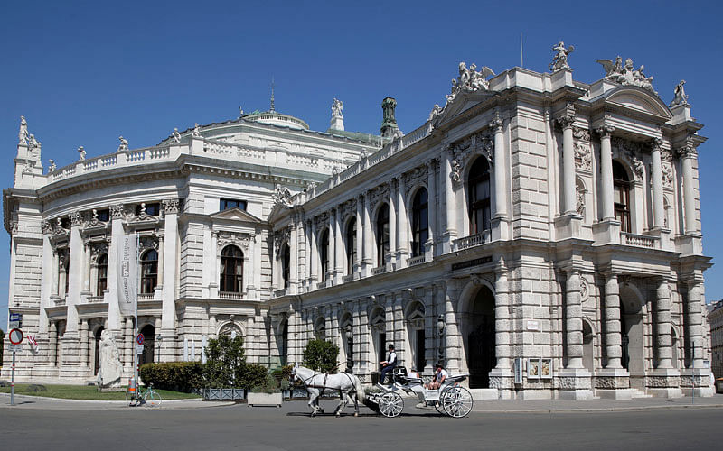 A traditional Fiaker horse carriage passes Burgtheater theatre in Vienna, Austria on 13 August. Photo: Reuters