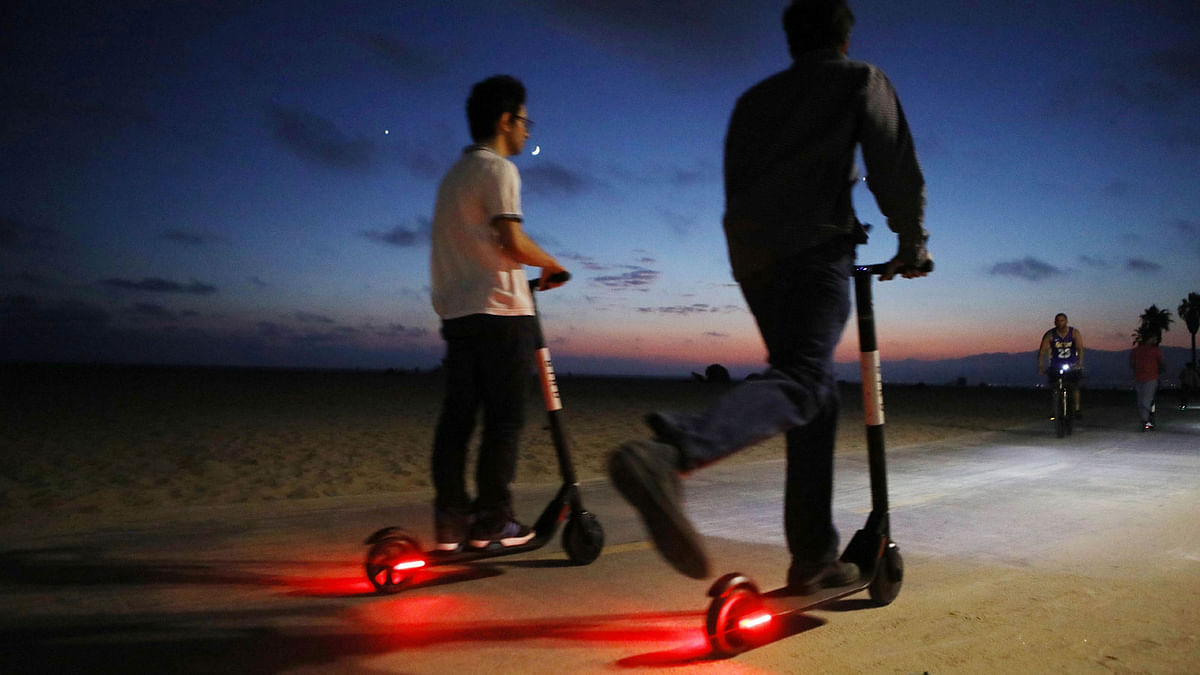 People ride shared dockless electric scooters along Venice Beach on 13 August, 2018 in Los Angeles, California. Photo: AFP