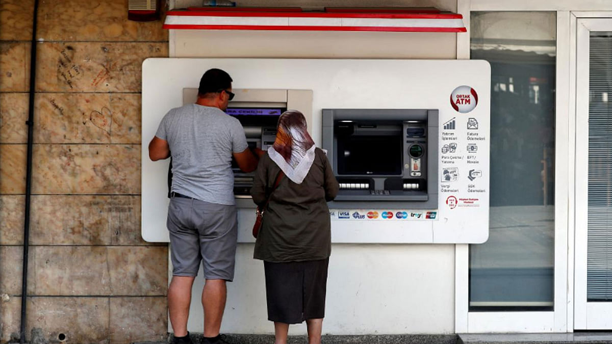 People withdraw money from a bank ATM in Izmir, Turkey on 18 August 2018. -- Reuters