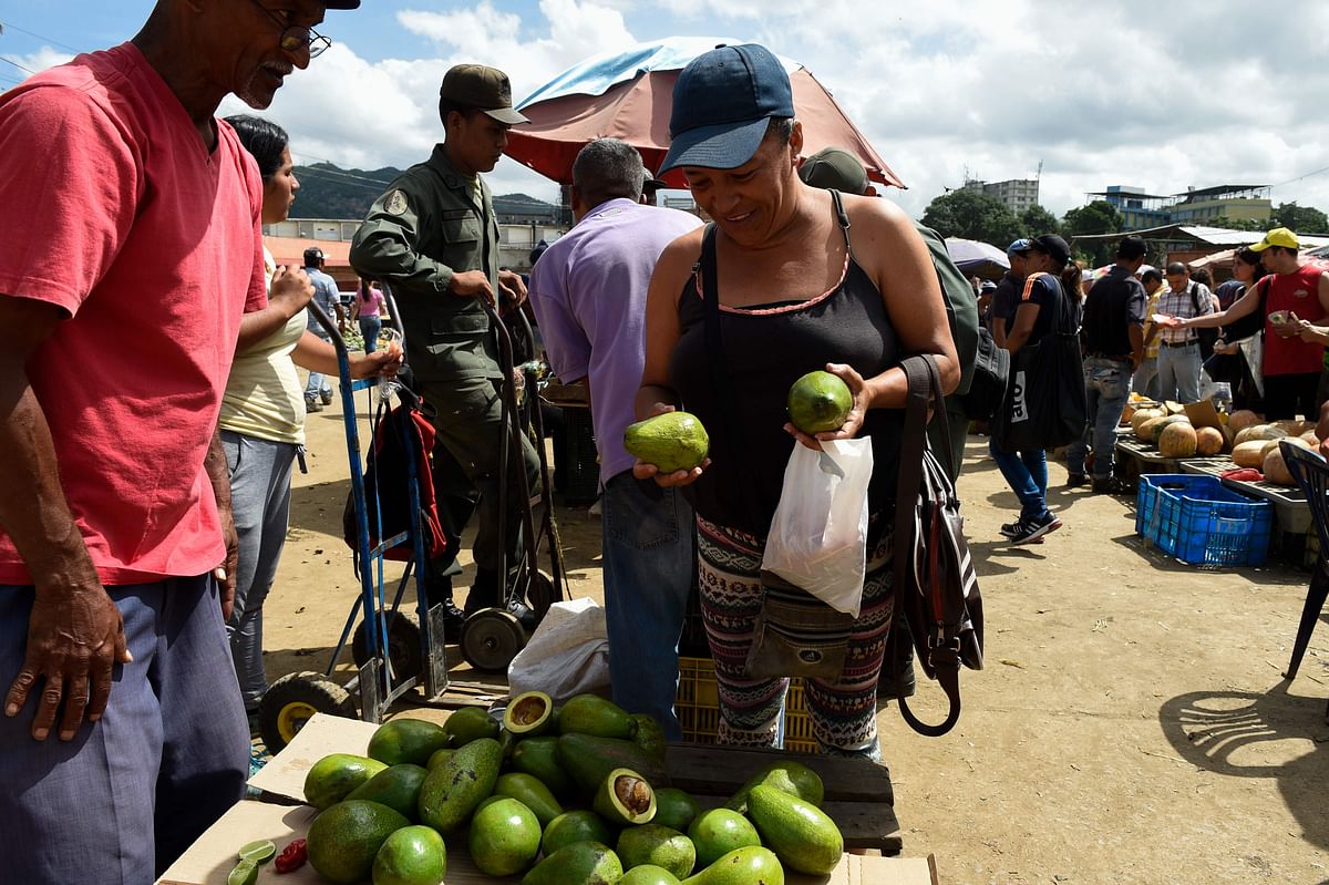 A woman buys vegetables at the municipal market of Coche, a neighbourhood of Caracas, on 18 August 2018 ahead of Monday, when Venezuela will start issuing new banknotes after slashing five zeroes off the crippled bolivar. Photo: AFP