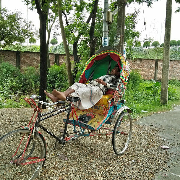 A rickshawpuller takes a nap on his rickshaw in a hot day. Nusrsat Nowrin takes this photo recently from Mahanagar Housing Society, Hatirjheel, Dhaka.