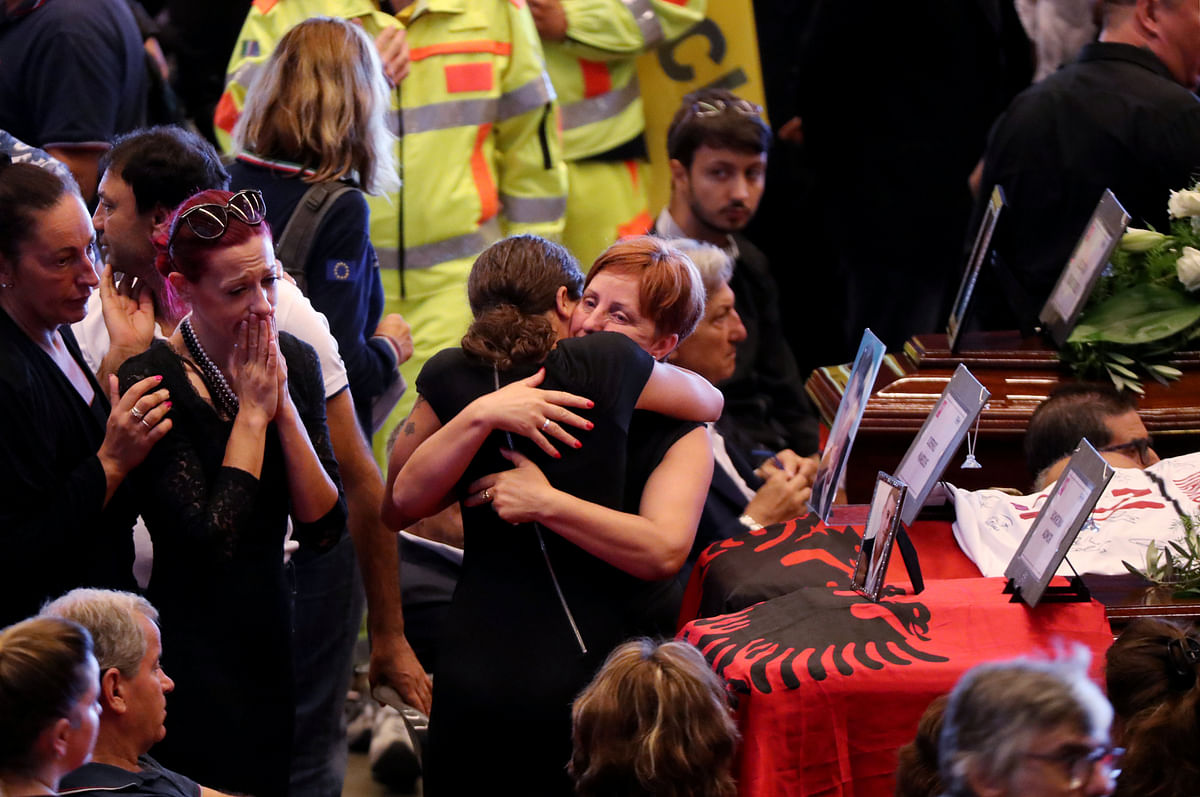 People mourn next to the coffins containing bodies of victims of the Genoa bridge collapse, at the Genoa Trade Fair and Exhibition Centre in Genoa, Italy on 18 August. Photo: Reuters