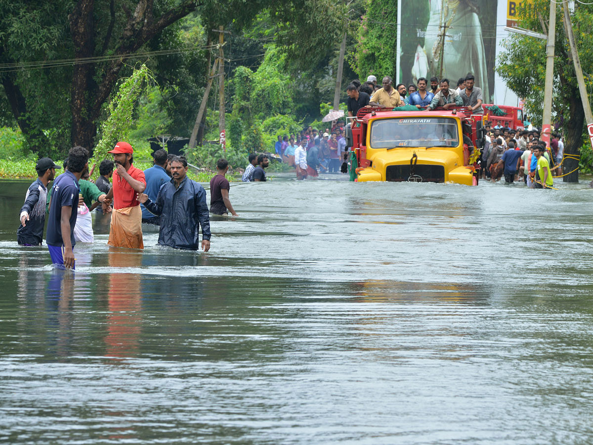 A truck carries people past a flooded road in Thrissur, in the southern Indian state of Kerala on 18 August. Photo: AP