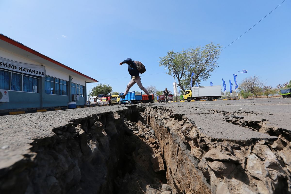 A man jumps over a crack in the ground in Mataram on Indonesia`s Lombok island on 20 August 2018 after a series of earthquakes were recorded by seismologists throughout 19 August. A series of powerful earthquakes have rocked the Indonesian holiday island of Lombok, killing at least 10 people and setting off fresh waves of panic after nearly 500 died there following a huge tremor two weeks ago. -- Photo: AFP