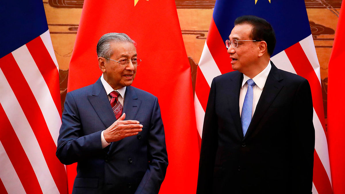 Malaysia`s prime minister Mahathir Mohamad (L) and China`s premier Li Keqiang talk during a signing ceremony at the Great Hall of the People in Beijing on 20 August.