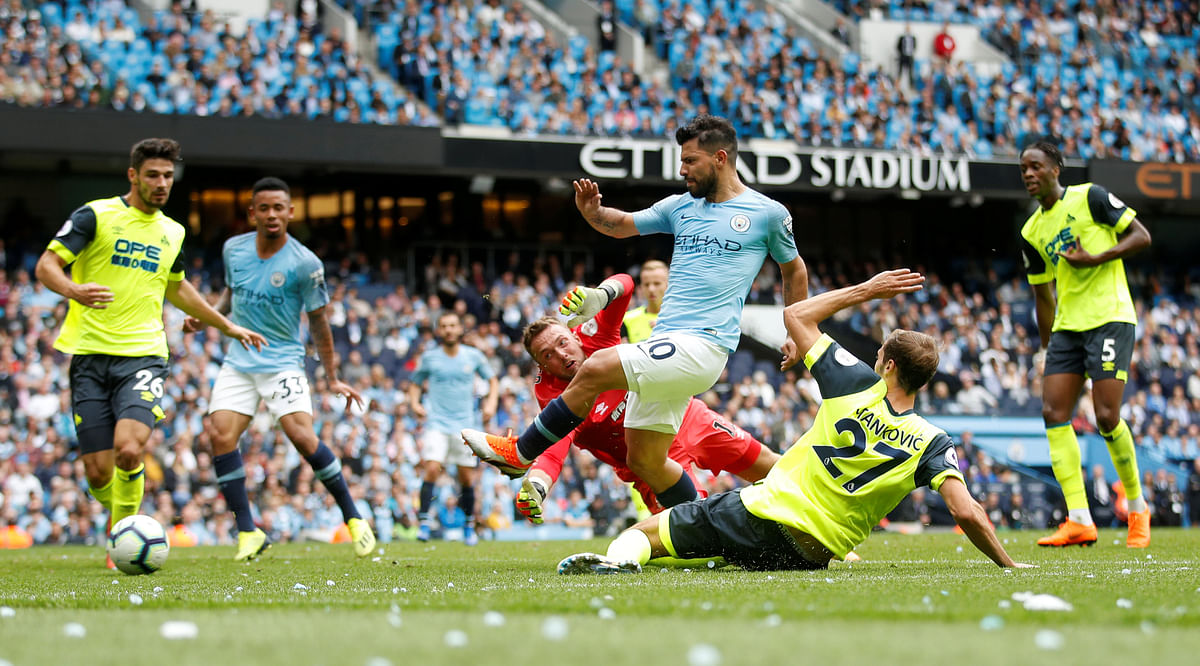 Manchester City`s Sergio Aguero scores their third goal while Huddersfield Town`s Ben Hamer looks on. Photo: Reuters