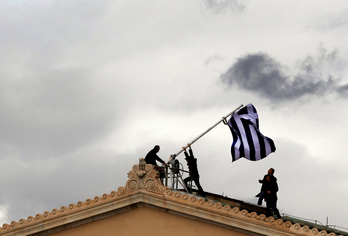 Greek parliament employees raise a mast after they replaced torn-off Greek flag with a new one atop the parliament in Athens Syntagma (Constitution) square on 18 April, 2012. Photo: Reuters
