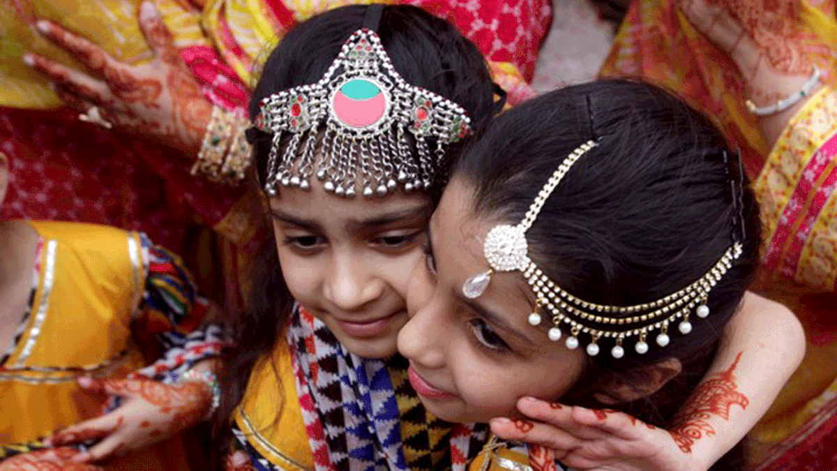 Children with traditional jewelry hug each other during Eid al-Adha celebration in Lahore, Pakistan on 22 August 2018. Photo: Reuters
