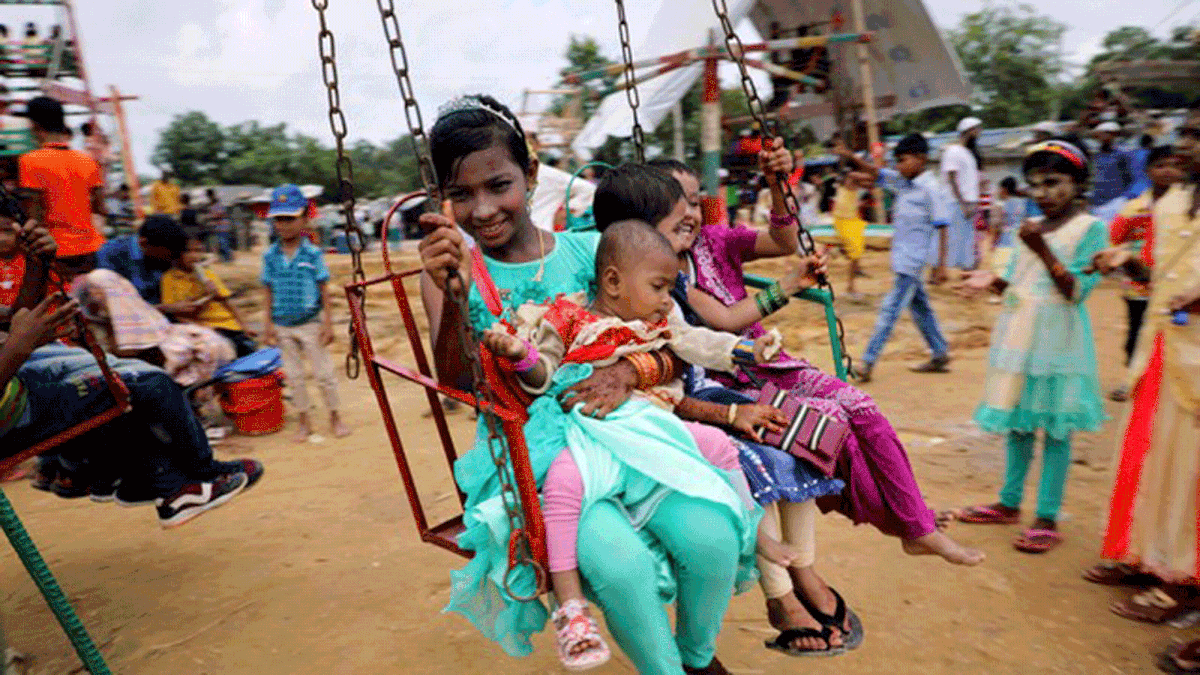Rohingya refugee children ride on a swing ride on the day of Eid al-Adha in the Kutupalong refugee camp in Cox’s Bazar, Bangladesh on 22 August 2018. Photo: Reuters