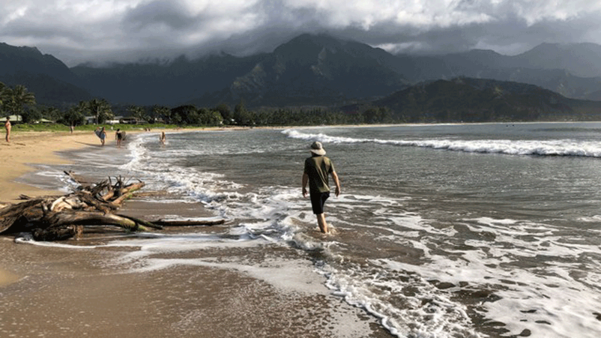 People walk along a calm Hanalei Beach as Hurricane Lane approaches Kauai, Hawaii, US on 22 August 2018. Photo: Reuters
