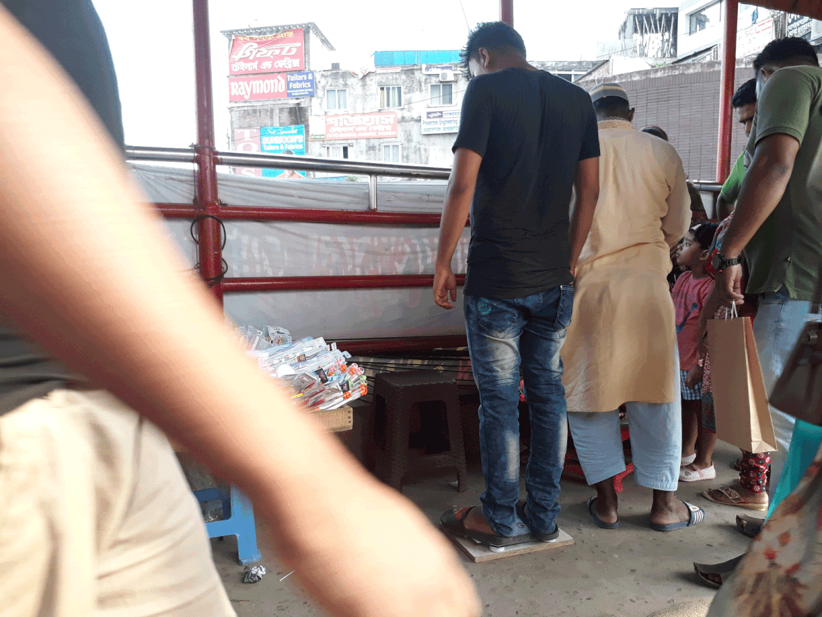 Rashedul takes a young boy’s weight in Karwan Bazar on 17 August. Photo: Shameem Reza