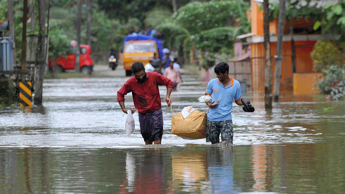 Indian men carry food and water aid distributed to those stranded by floods in Pandanad in Alappuzha District in the south Indian state of Kerala on 21 August 2018. More than one million people have swarmed relief camps in India`s Kerala state to escape devastating monsoon floods that have killed more than 410 people, officials said Tuesday as a huge international aid operation gathered pace. -- AFP