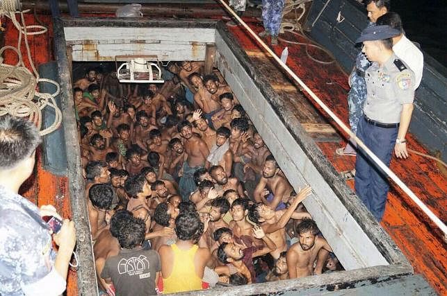 Migrants huddle in the compartment of a cargo vessel. AFP File Photo