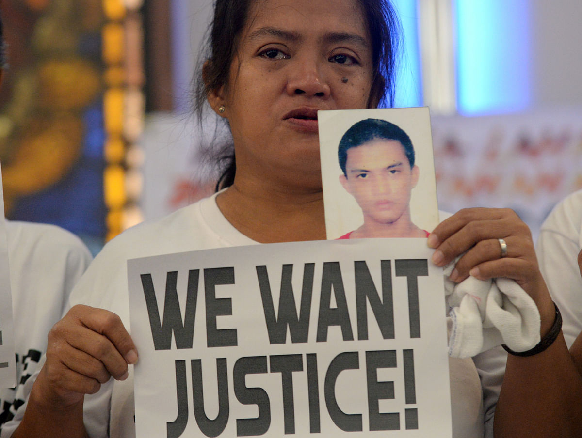 A woman displays a picture of her son, a drug war victim, and a placard during a protest against the war on drugs by President Rodrigo Duterte in Quezon city, Metro Manila in Philippines on 28 August. Photo: Reuters