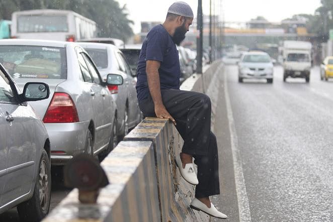 A man climbs over the divider, risking his life to cross the road quickly. Kurmitola General Hospital area, Dhaka on 29 August. Photo: Abdus Salam