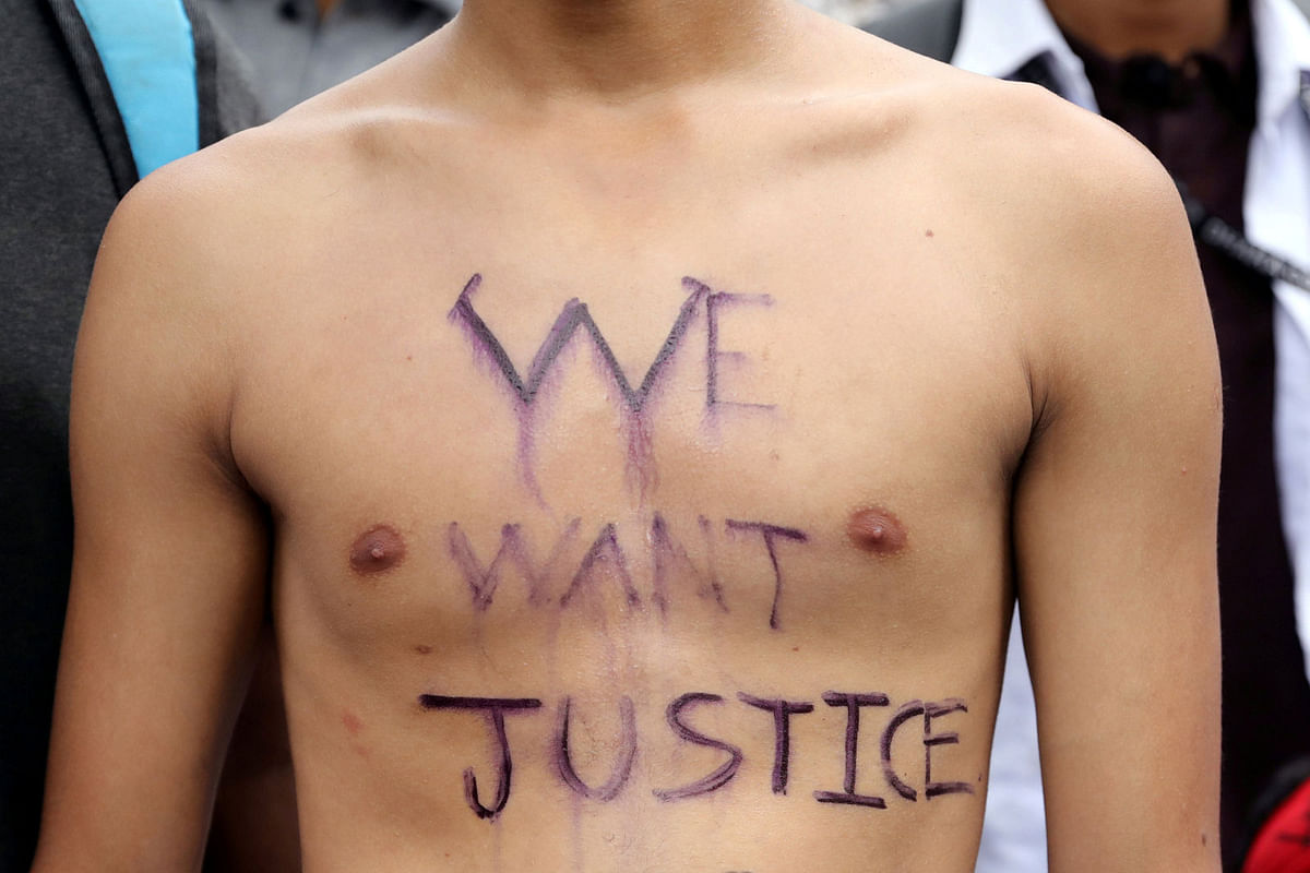 A slogan is written on the body of a student as he takes part in a protest over recent traffic accidents that killed a boy and a girl, in Dhaka. Photo: Reuters