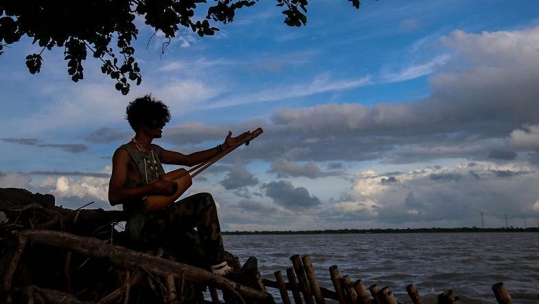 A baul sings by the river in an autumn afternoon in Kuchubunia, Batiaghata, Khulna on 27 August. Photo: Saddam Hossain