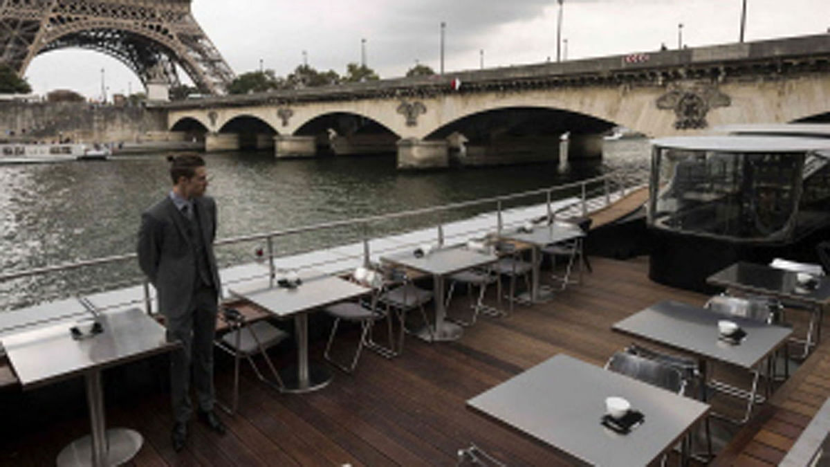 A waiter stands at French chef Alain Ducasse`s new boat restaurant, the `Ducasse sur Seine`, on 30 August 2018 in Paris, next to the Eiffel tower (L). Photo: AFP