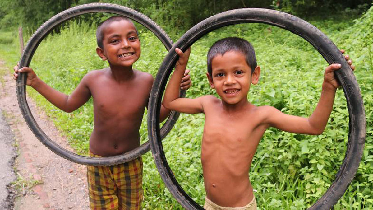 Two children play with tyres in Tarapur, Sylhet on 2 September. Photo: Anis Mahmud