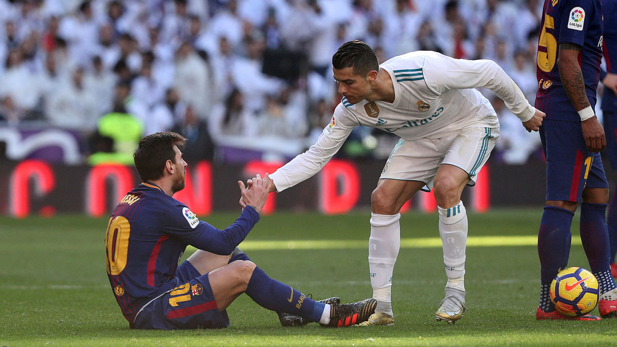 Real Madrid’s Cristiano Ronaldo helps Barcelona’s Lionel Messi get back to his feet on 23 December 2017. Photo: Reuters
