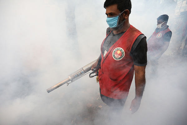 Two workers of Dhaka North City Corporation (DNCC) are seen working with fogging machines to smoke out midges especially mosquitoes as Dengue outbreak has intensified in the capital. Dipu Malakar took the photo from Tejkunipara area of Dhaka on 4 September.