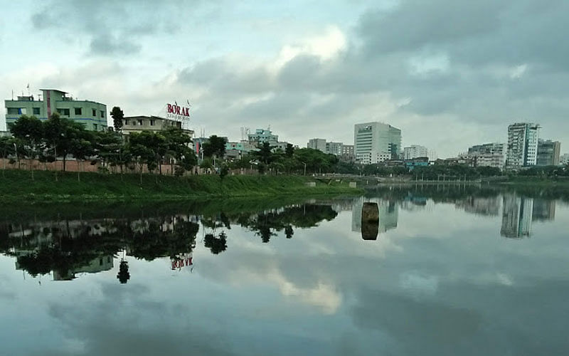 A recent photo shows reflections of buildings, trees and cloud on the calm water of Hatirjheel, Dhaka in a morning. Photo: Nusrat Nowrin