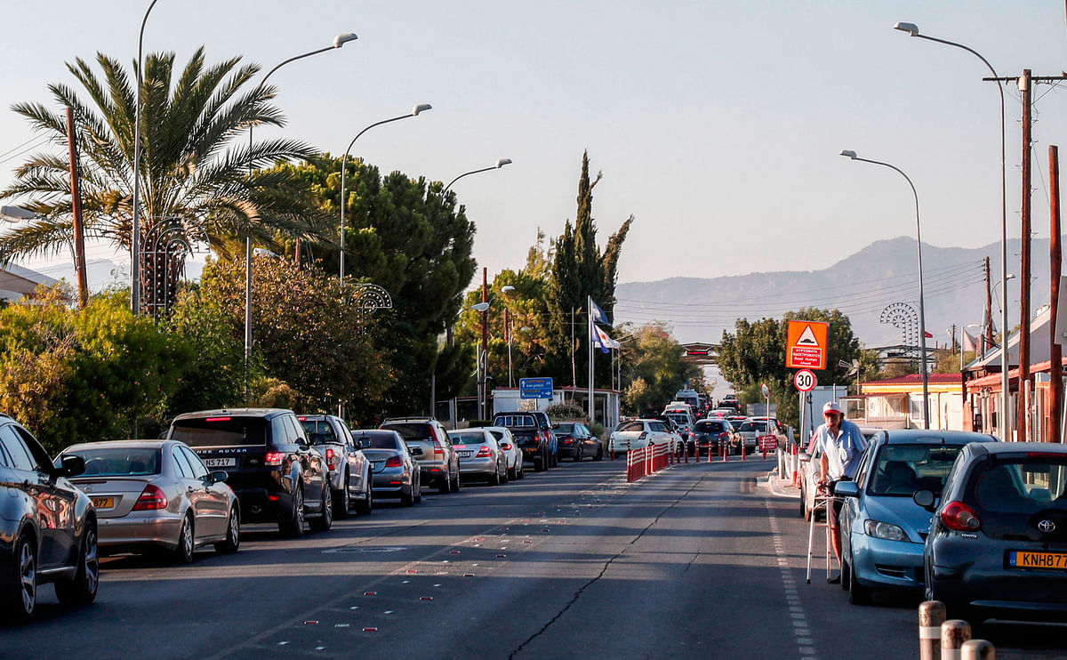 This picture taken on 31 August 2018, shows cars queueing up to cross from the Cypriot capital Nicosia, through the Ayios Dometios border checkpoint with the buffer zone that slices between the internationally recognised Republic of Cyprus and the Turkish-occupied north. Photo: AFP
