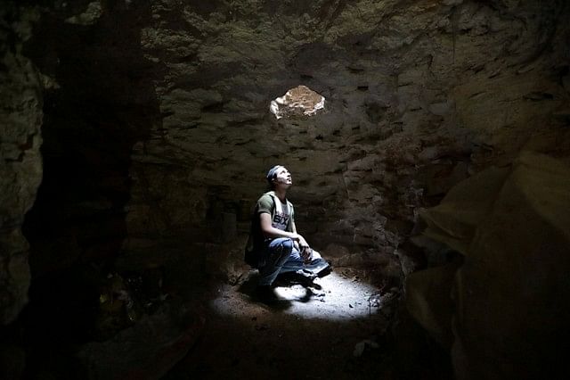 A man looks at an opening from a makeshift shelter in an underground cave in Idlib, Syria 3 September 2018. Photo: Reuters