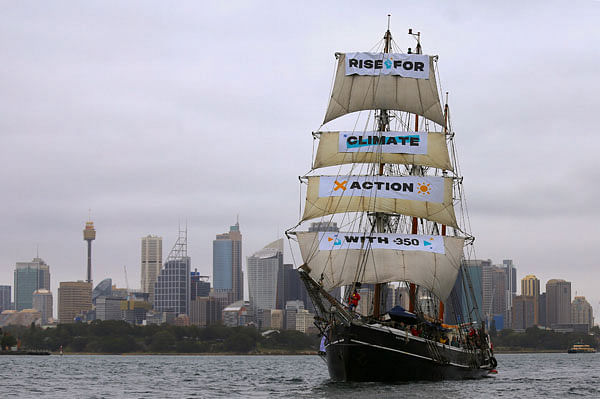 The picture shows a tall ship displaying banners as it sails on Sydney Harbour in Australia, 8 September 2018 as part of global climate change protests across 95 countries organised by the New York-based lobby group 350.org. Steven Saphore-350.org. Photo: Reuters