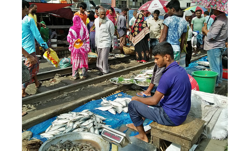Fish market on the train line in Karwan Bazar, Dhaka on 9 September. Though the train frequently runs over the track, the sellers sit in the area and buyers buy fish regularly risking their lives. Photo: Nusrat Nowrin