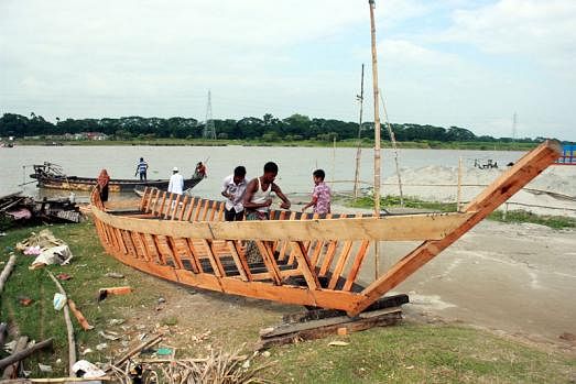 Boatbuilders busy with works by the river Brahmaputra at Kacharighat, Mymensingh on 8 September. Photo: Anwar Hossain
