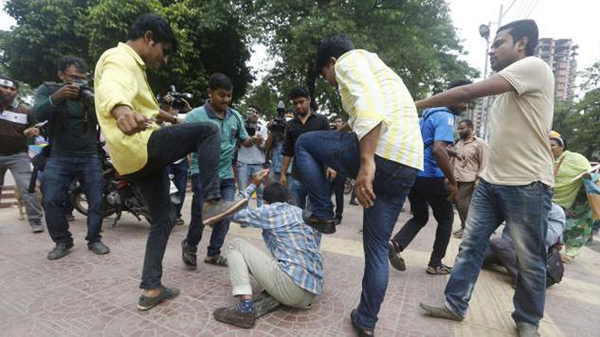 A demonstrating student is being beaten. Prothom Alo File Photo