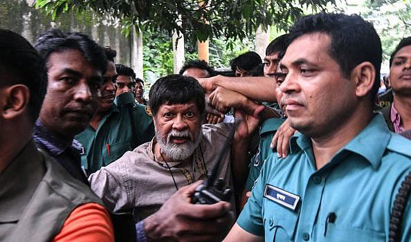 Activist and photographer Shahidul Alam arrives surrounded by policemen for an appearance in a court in Dhaka on 6 August. Photo: AFP