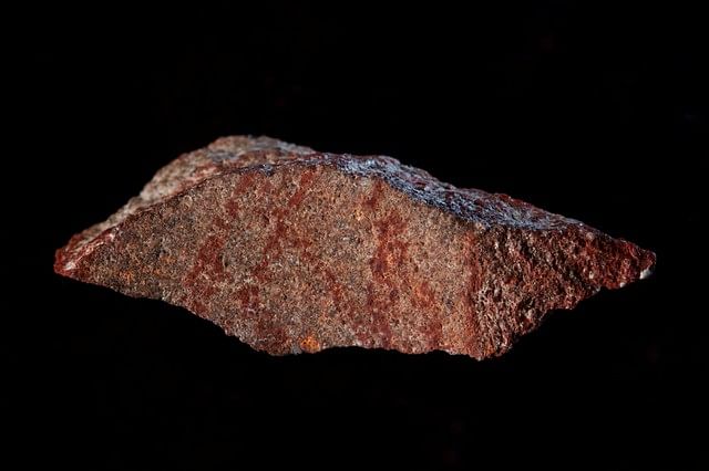 A stone flake discovered in Blombos Cave with red ochre markings that archeologists say represent one of the oldest-known examples of human drawings, on South Africa`s southern coast is shown in this photo released on 12 September 2018. Photo: Reuters