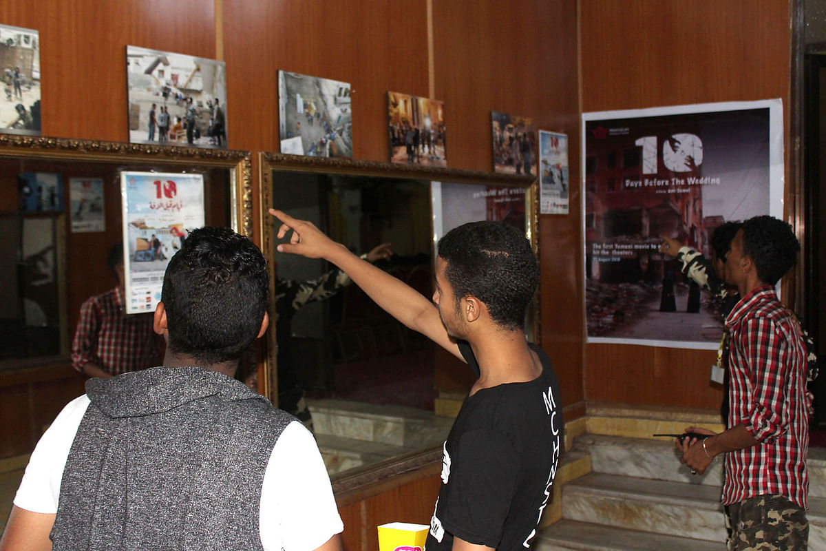 Yemeni men watch movie posters prior to the screening of the movie `10 Days Before the Wedding` at a cinema of the Southern city of Aden on 13 September, 2018. Photo: AFP