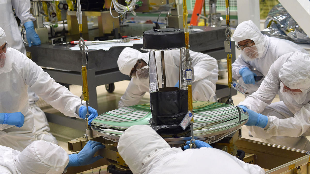 In this 16 October 2014, image obtained from NASA, engineers and technicians check the fit of ICESat-2’s telescope to its sling, before moving it into place on the instrument’s optical bench. Photo: AFP