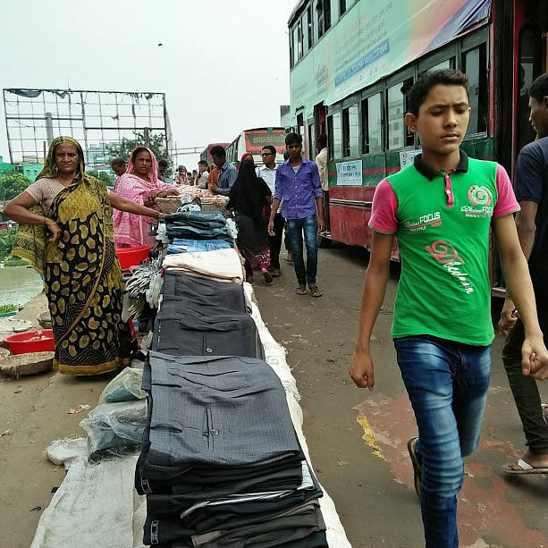 This 14 September photo shows street vendors sit occupying pavement of a bridge on Turag river along the Dhaka-Mymensingh Highway in Tongi, Gazipur. The pedestrians are compelled to use the highway risking their lives every day. Photo: Nusrat Nowrin