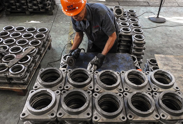 An employee works on transmission parts at a factory in Lianyungang in China`s eastern Jiangsu province on 14 September 2018. Photo: AFP