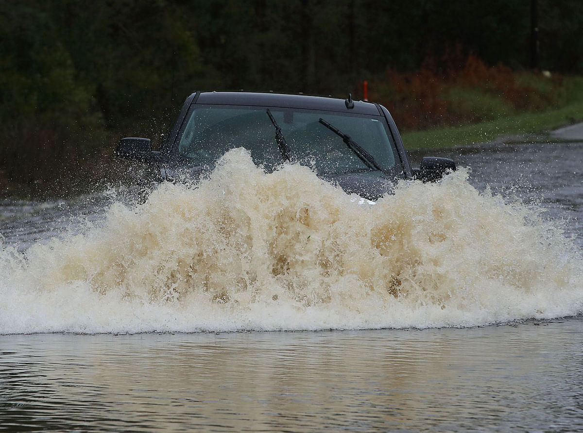 A motorist successfully navigates through a flooded road on 16 September 2018 in Leland, North Carolina. Hurricane Florence hit area as a Category 1 storm causing widespread damage and flooding across North Carolina. Photo: AFP
