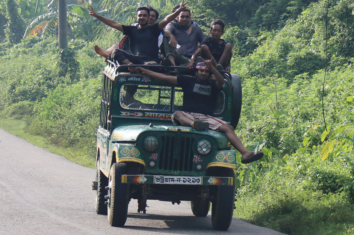 Young tourists having a risky ride on a human hauler, after visiting the Risang spring, Alutila cave, Buddha Bihar, and Tareng prior to their Khagrachhari trip. Shilachhara, Khagrachhari, 16 September. Photo: Nerob Chowdhury