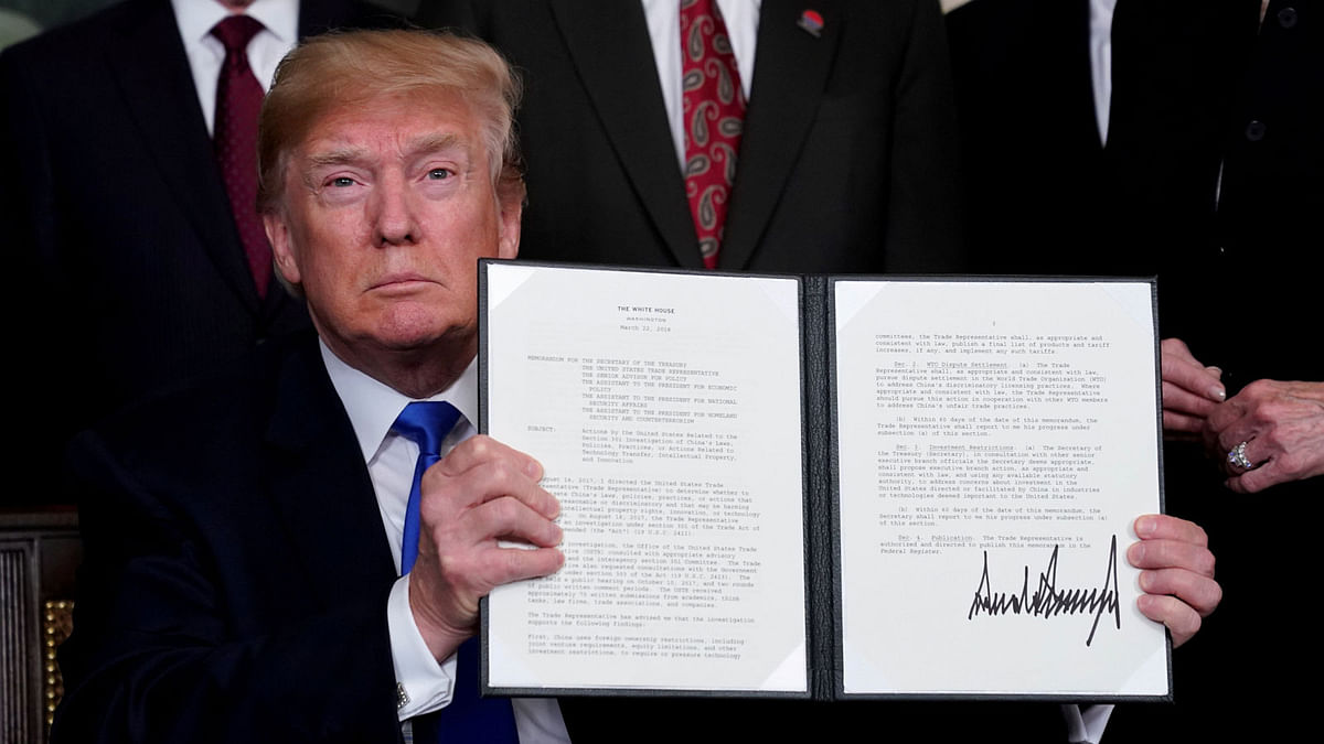 US president Donald Trump holds his signed memorandum on intellectual property tariffs on high-tech goods from China, at the White House in Washington on 22 March. Photo: Reuters