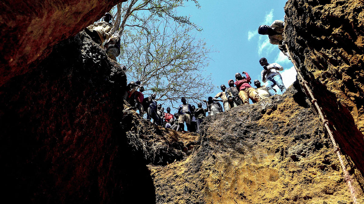Illegal miners stand on top of a ditch where they search for precious stones on 3 August 2018, in Nthoro village, on the outskirts of the mining town of Montepuez, Mozambique. The discovery of rubies by a local woodcutter just nine years ago sparked a `ruby rush` in Mozambique, which now accounts for 80 per cent of the world`s production, but Instead of riches and reward, what could have been a windfall has brought harassment, violence and even a local ban on farming. Photo: AFP