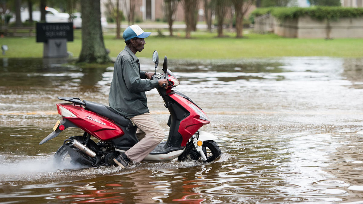 A man rides a scooter through floodwaters from Hurricane Florence on 17 September 2018, in Conway, South Carolina. Photo: AFP