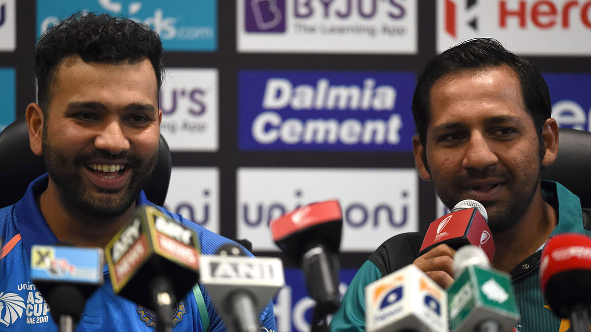 Pakistan cricket captain Sarfraz Ahmed (R) speaks during an Asia Cup press conference as Indian cricket team captain Rohit Sharma looks on at the Dubai International Cricket Stadium in Dubai on 14 September, 2018, ahead of the start of the 2018 Asia Cup cricket tournament. Photo: AFP