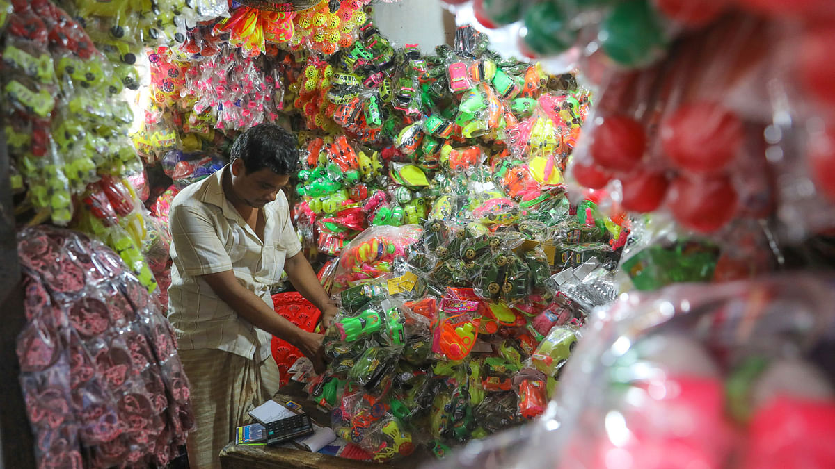 A wholesale trader busy in his plastic toy shop at Chawk Bazar, Dhaka on 14 September. Price ranges from Tk 20 to 450 depending on variety. Photo: Dipu Malakar