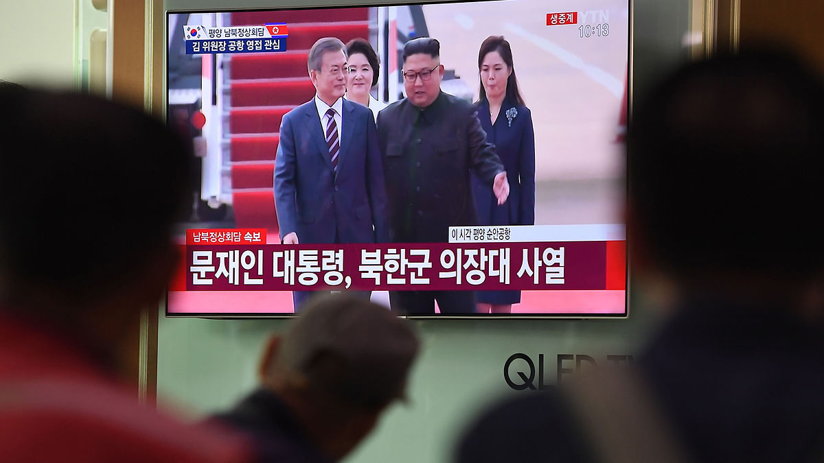 People watch a screen showing live footage of the arrival of South Korean president Moon Jae-in at Pyongyang airport as North Korean leader Kim Jong Un welcoms him, at a railway station in Seoul on 18 September. Photo: AFP
