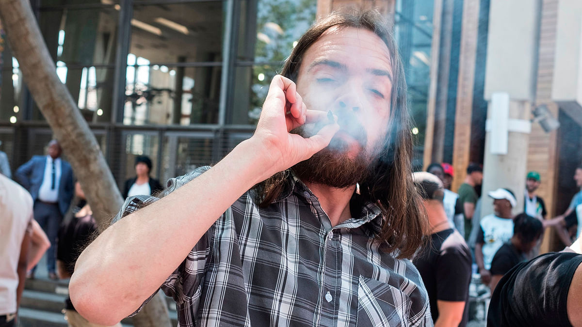 A man smokes a joint after South Africa’s top court ruled that personal cannabis use is legal on 18 September outside the Constitutional Court in Johannesburg. Photo: AFP