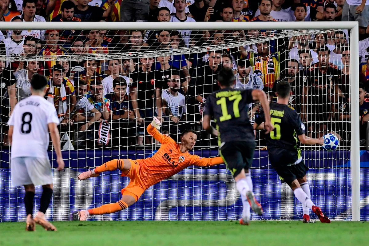 Juventus` Bosnian defender Miralem Pjanic (R) scores against Valencia`s Brazilian goalkeeper Neto during the UEFA Champions League group H football match between Valencia CF and Juventus FC at the Mestalla stadium in Valencia on 19 September 2018. Photo: AFP