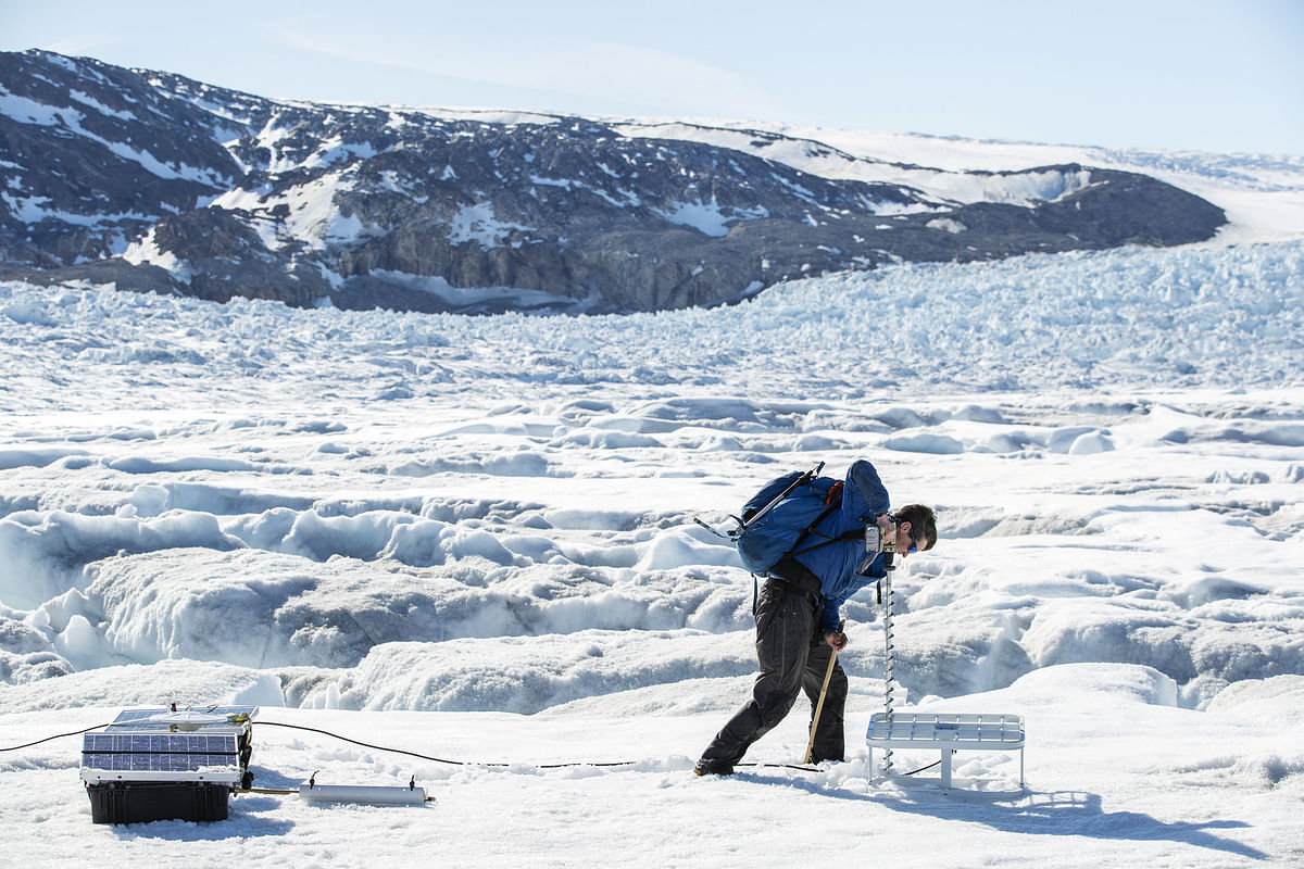 Safety officer Brian Rougeux uses a drill to install antennas for scientific instruments that will be left on top of the Helheim glacier near Tasiilaq, Greenland, on 19 June 2018. Photo: Reuters